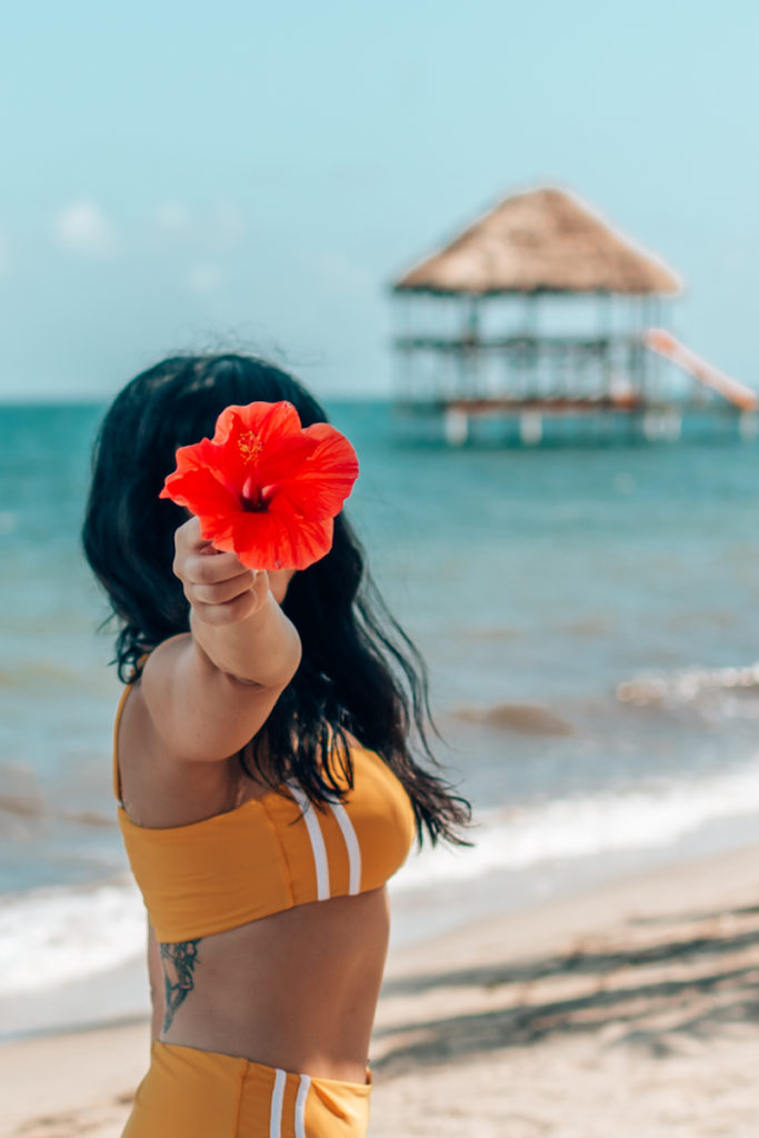 props for photoshoots - woman holding red tropical flower