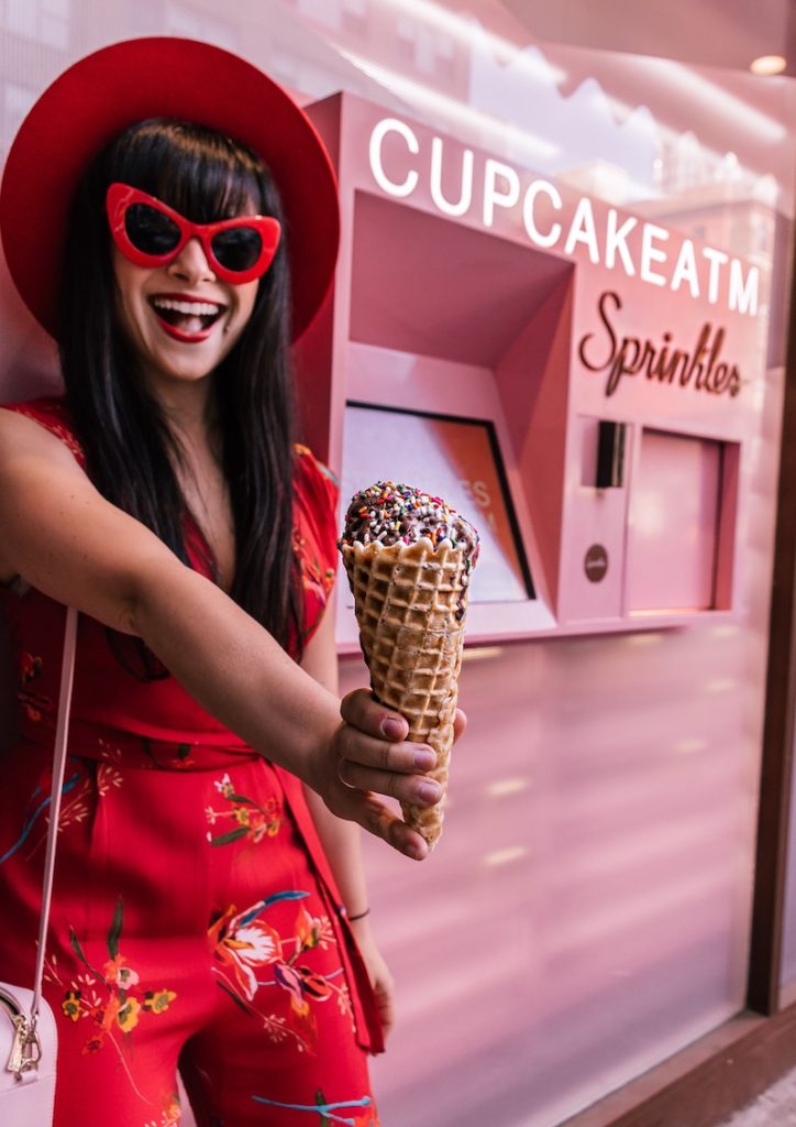 Woman wearing red holding ice cream cone