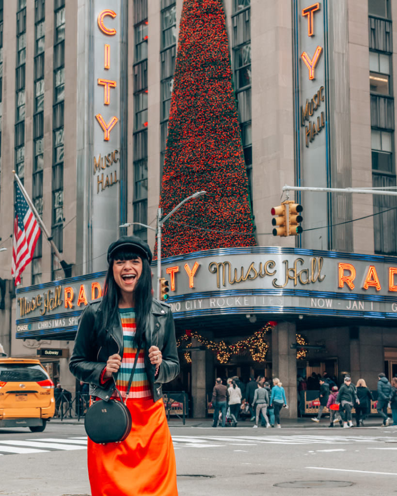 Woman standing in front of Radio City Music Hall in NYC
