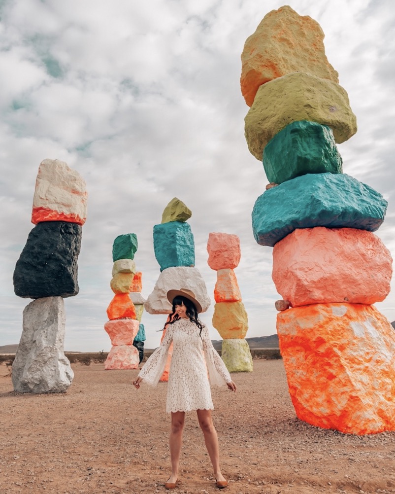 Woman standing in front of large colorful statues