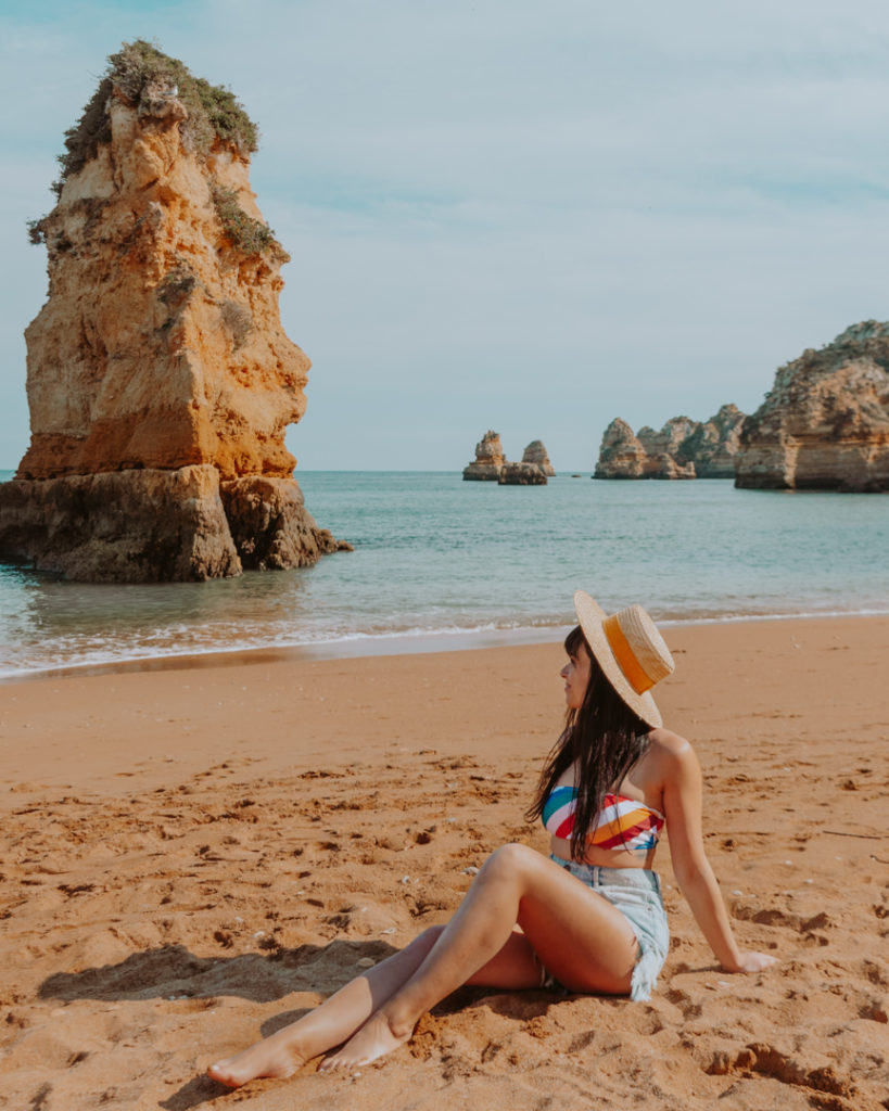 Woman in straw hat sitting on beach