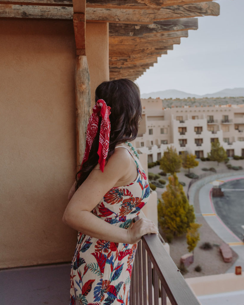 Woman with hair bow looking off balcony