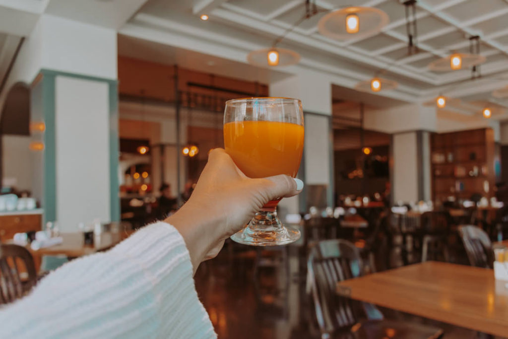 Woman's hand holding glass of orange juice