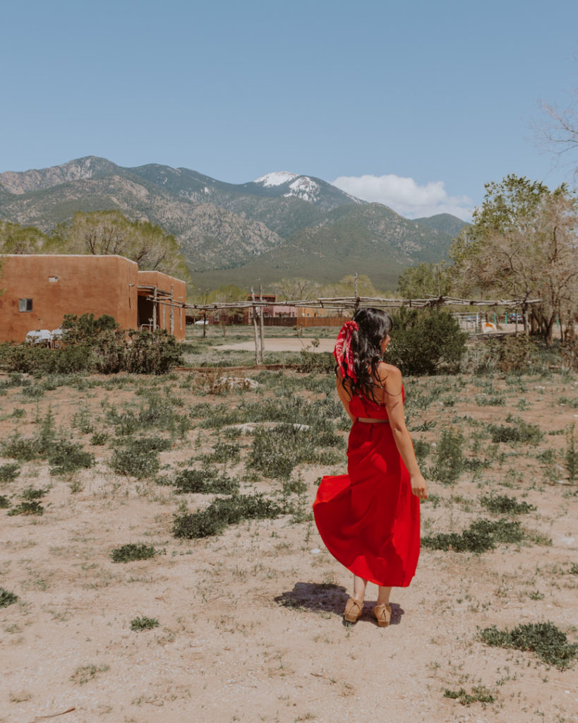 Woman in red dress near Taos mountain