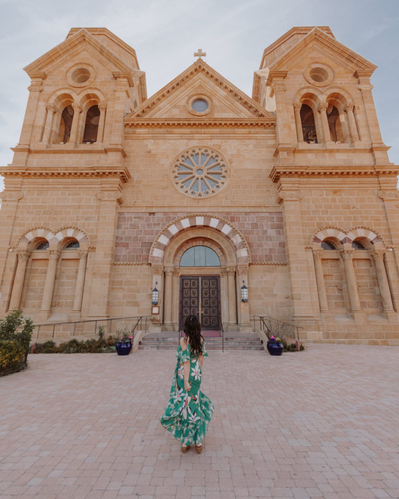 Woman in green dress in front of cathedral