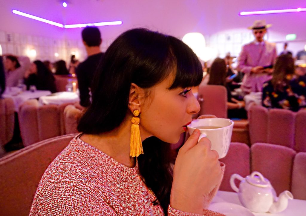 Woman sipping tea in pink restaurant