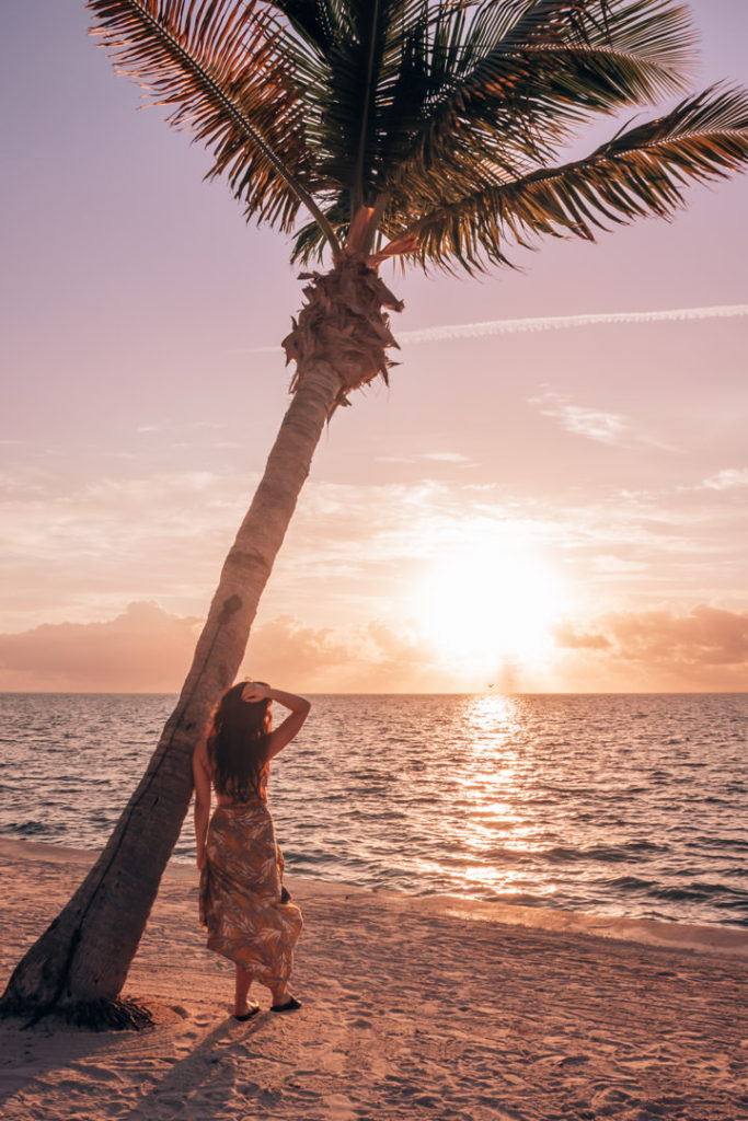 Woman leaning on palm tree