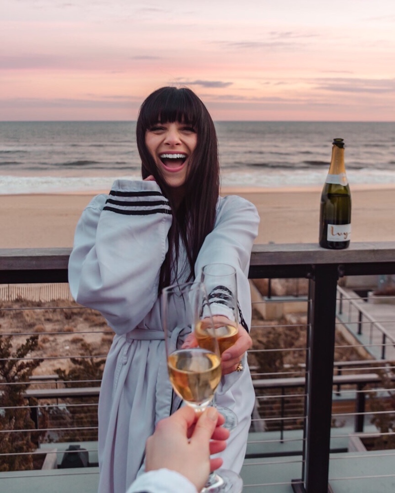 Woman in bathrobe holding champagne glass 