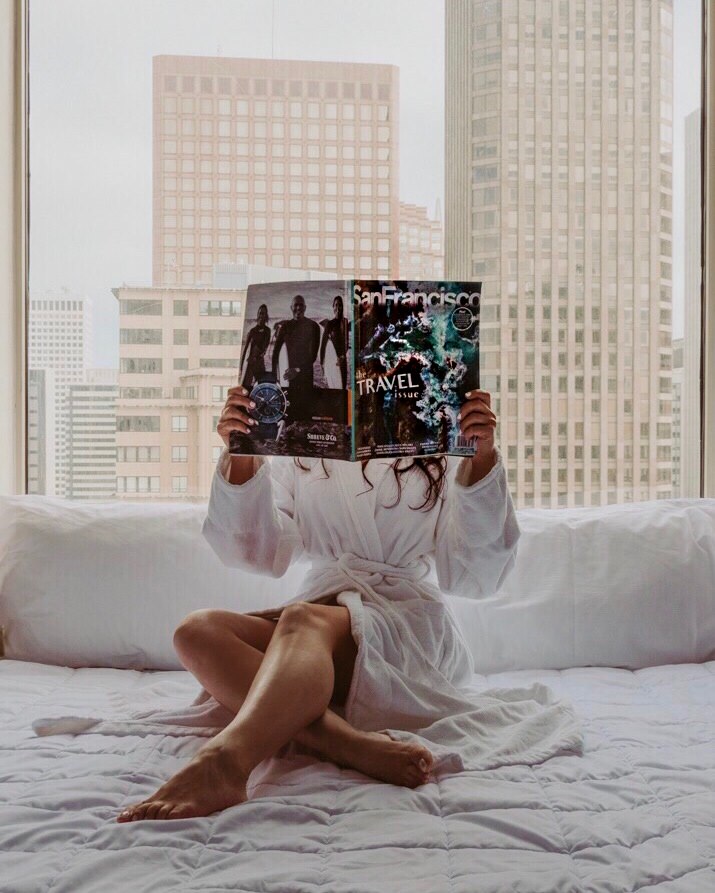 Woman in bathrobe holding magazine