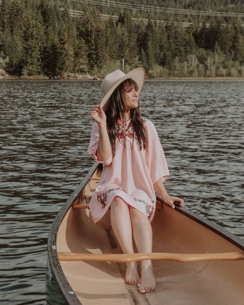 woman in pink dress sitting in canoe