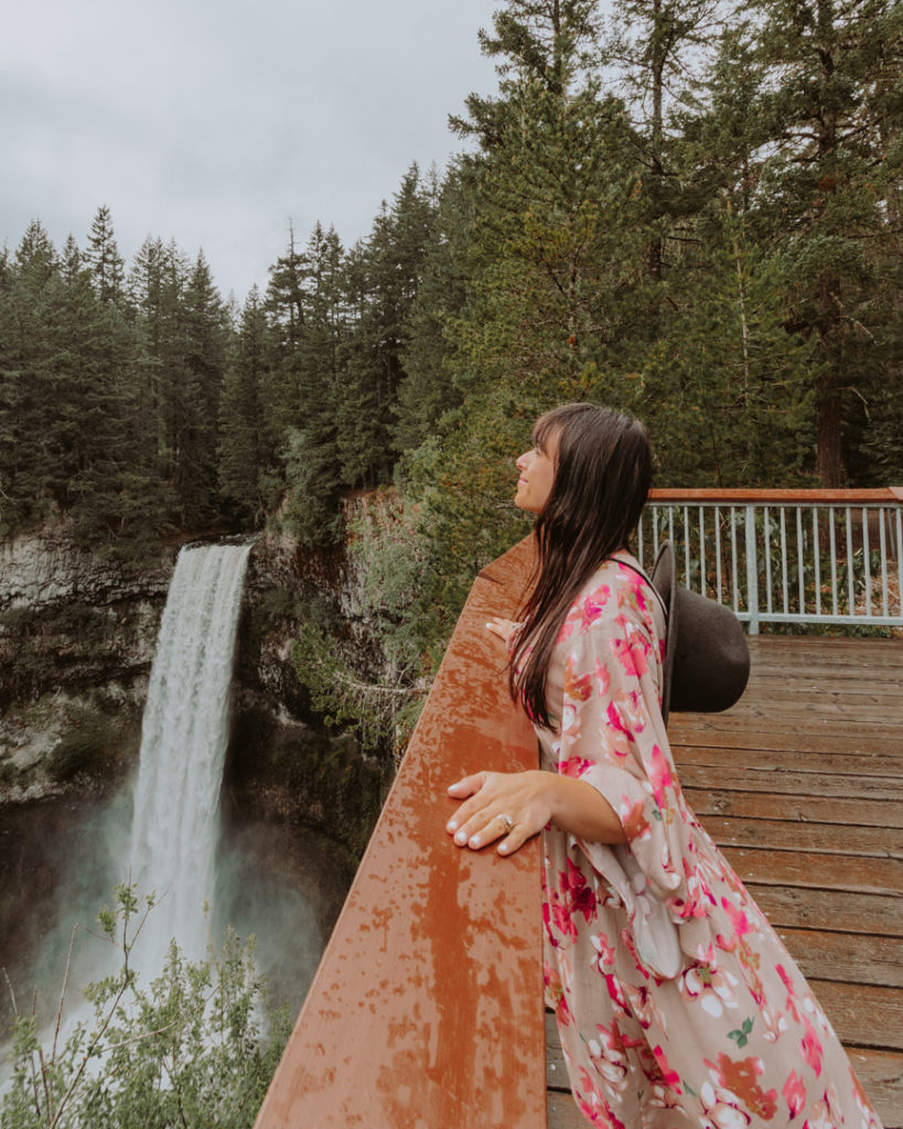 A woman looking at a large waterfall
