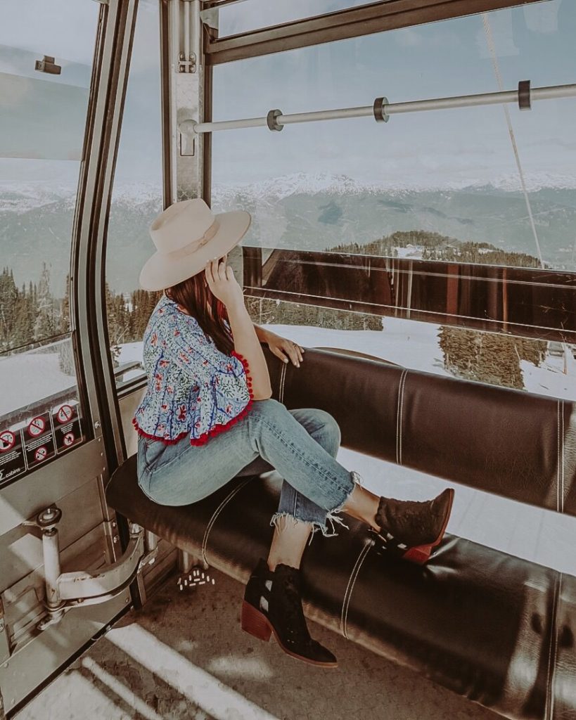 woman in hat sitting in glass sided gondola