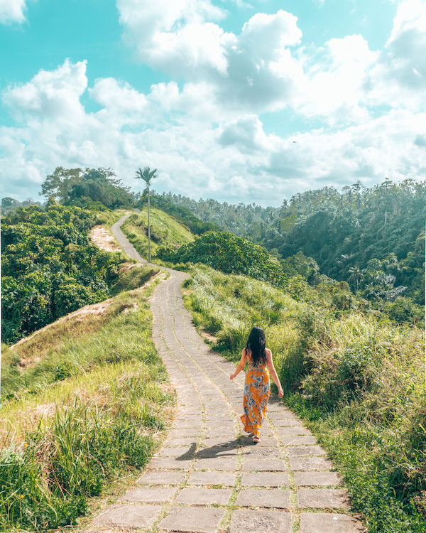 Woman in dress walking down jungle path