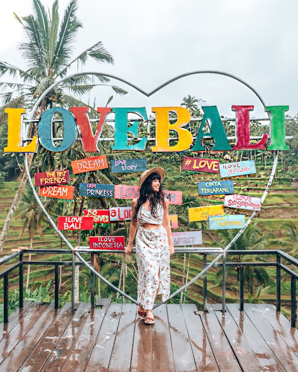 Woman standing in front of multicolored Love Bali sign
