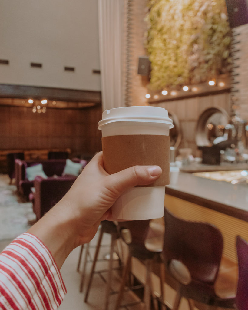 Hand holding latte at Thompson Chicago hotel