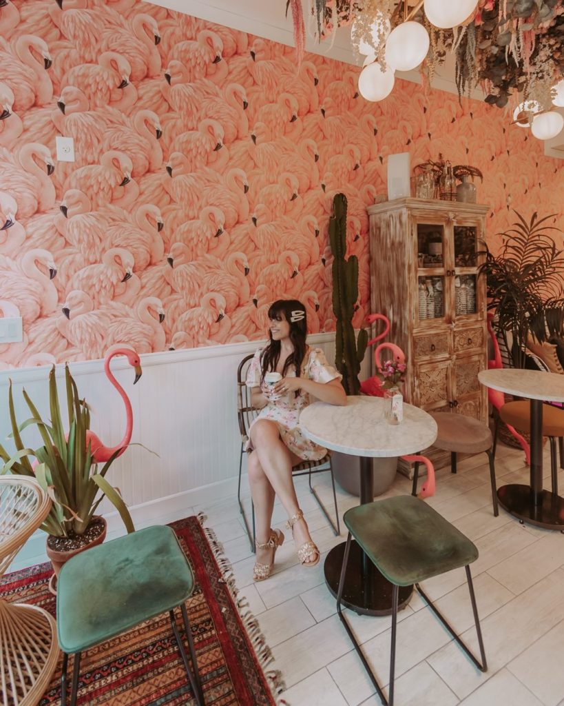 Woman sitting in pink coffee shop