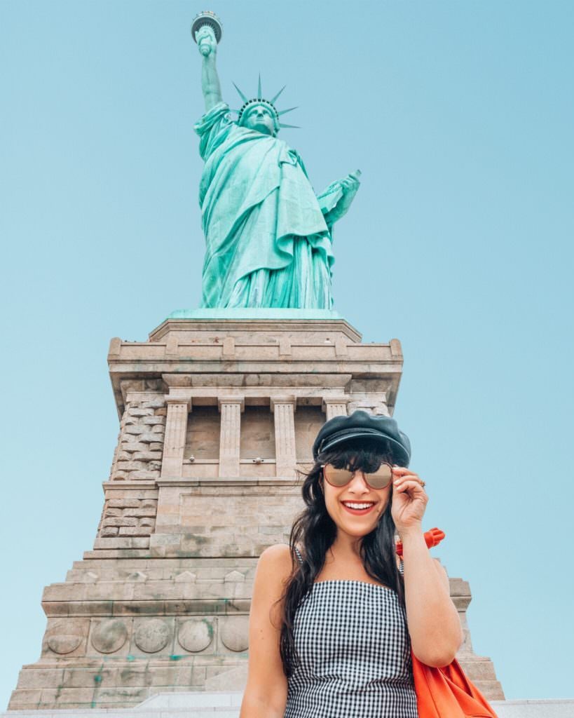 Woman standing in front of Statue of Liberty