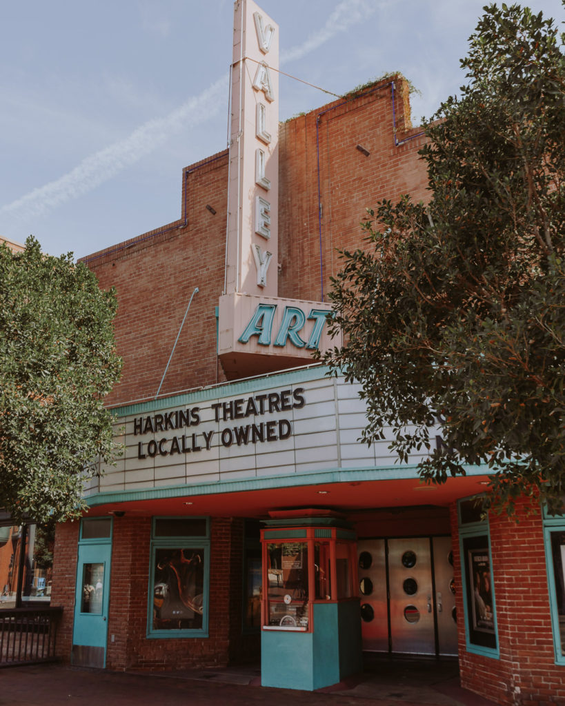 exterior of a pink and turquoise old fashioned movie theater