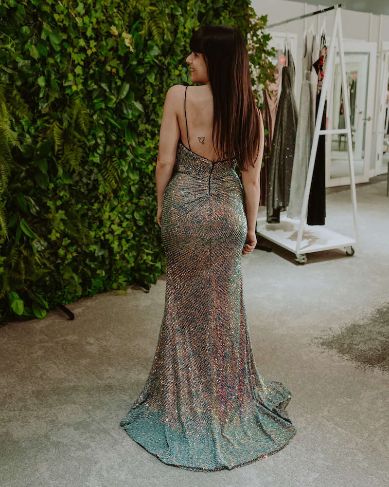 Woman with brown hair showing back of long dress