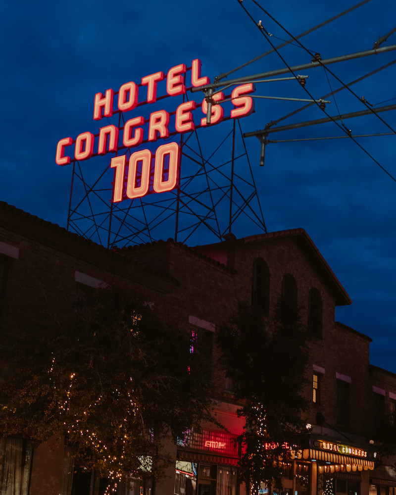 Exterior of hotel at night with large neon sign