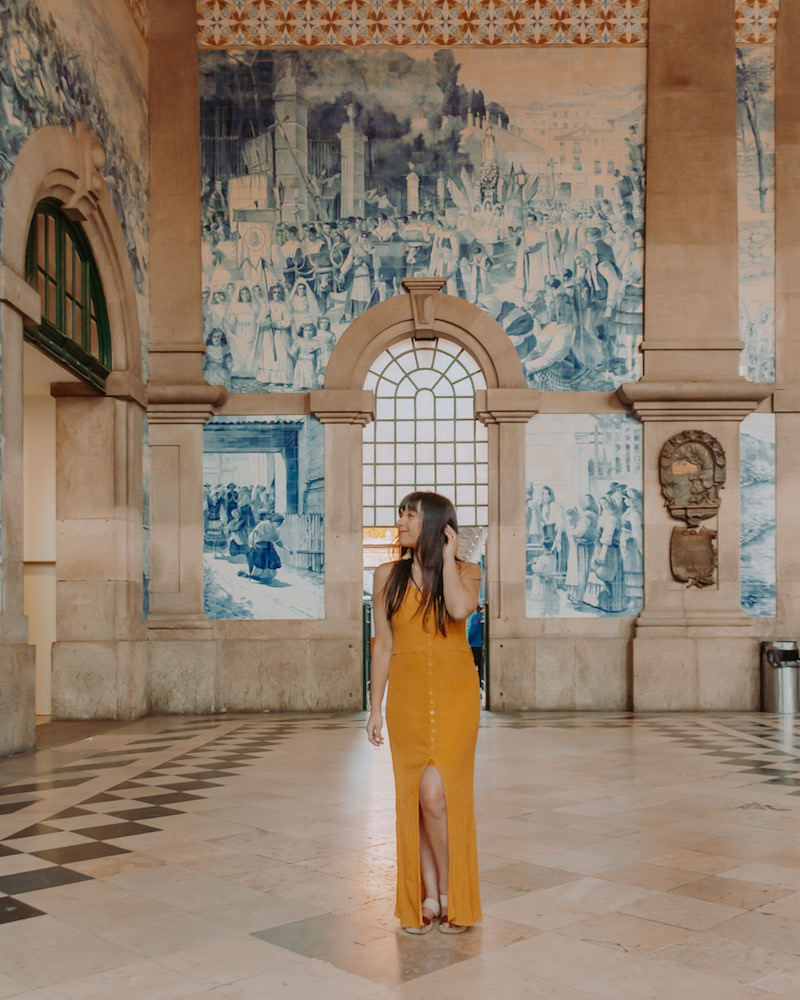 Woman in yellow dress standing in train station lobby