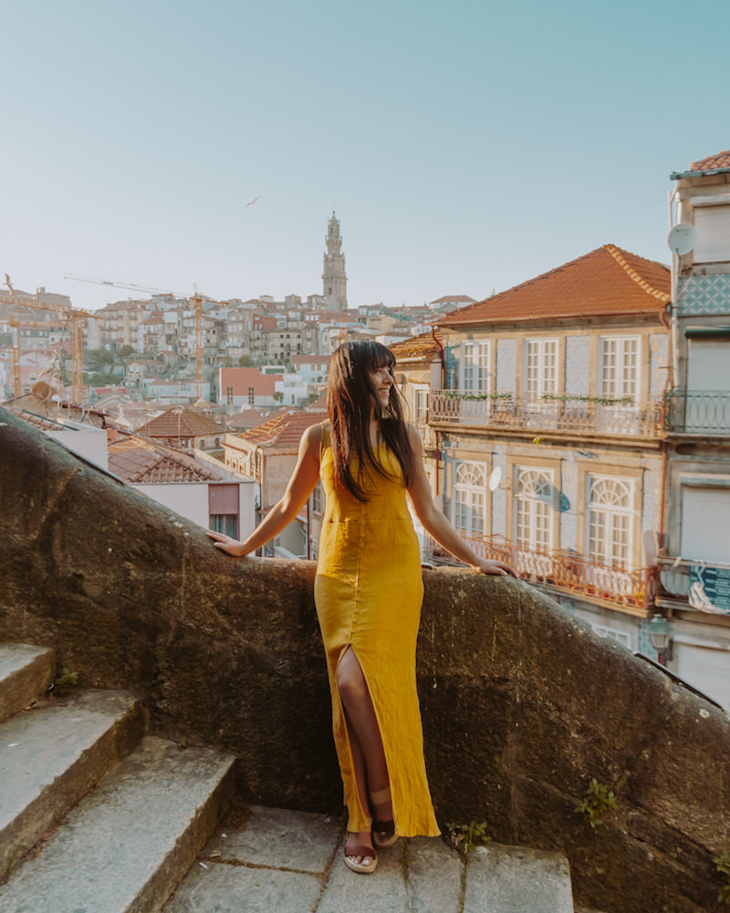 Woman in yellow dress standing on old stone staircase 