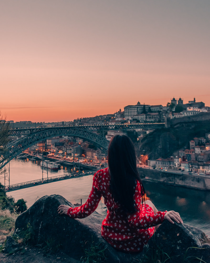 Woman sitting looking at sunset over Porto Portugal 