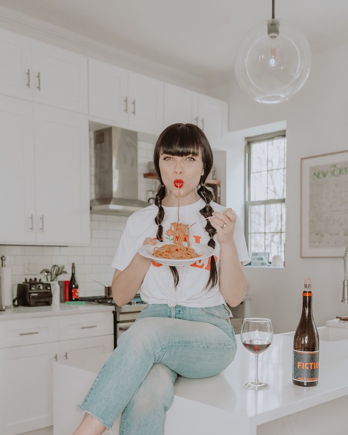 Props for photoshoots - woman eating pasta in white kitchen