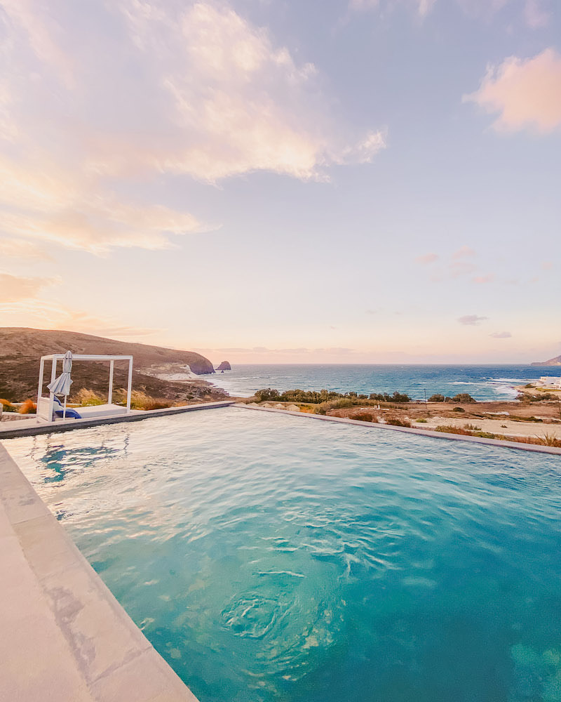 An infinity pool at sunset that overlooks the ocean.